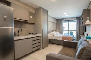 嘎林海斯港Apartamento Cupe Beach Living的厨房以及带床和沙发的卧室。
