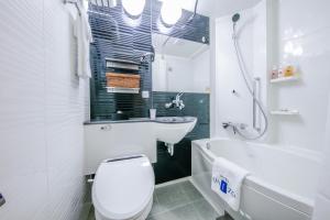 大阪大阪梅田由尼森酒店的浴室配有卫生间、盥洗盆和浴缸。