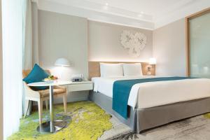 曼谷曼谷假日酒店的配有一张床和一张书桌的酒店客房
