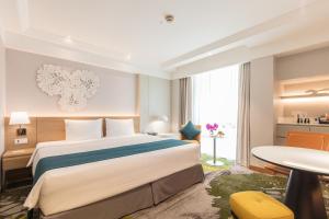 曼谷曼谷假日酒店的酒店客房设有一张大床和一张桌子。