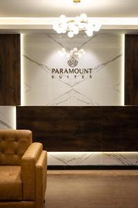 门格洛尔Hotel Paramount Suites & Service Apartments的大堂设有椅子和墙上的标志