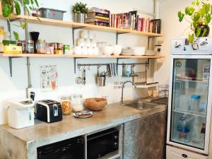 曼谷HOLY SHEET Hostel的厨房配有带水槽的柜台和冰箱。