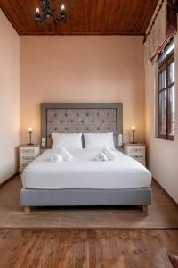 干尼亚Old Town Suites的一间卧室配有一张带2个床头柜的大型白色床