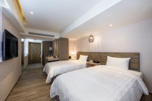 嘉义市兰桂坊花园酒店的酒店客房设有两张床和一台平面电视。