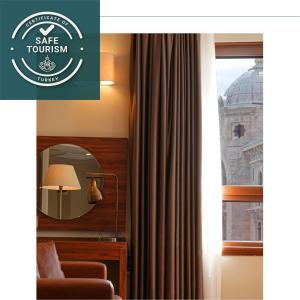 伊斯坦布尔Grand Sirkeci Hotel的一张房间的照片,房间设有窗户和镜子