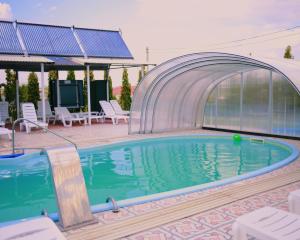萨塔尼夫VitaPark Sonyachnyy Provans的四周环绕着玻璃墙的游泳池