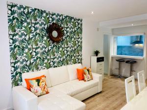 马德里Palacio Apartments Madrid的客厅配有白色沙发和花卉墙
