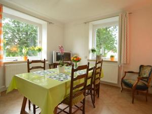 比特亨巴赫Holiday Home with Garden Heating Barbecue的一间带桌椅和2扇窗户的用餐室