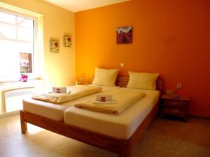 摩泽尔河畔的泽尔Ferienhaus Alte Mühle的一间卧室设有两张带橙色墙壁的床。