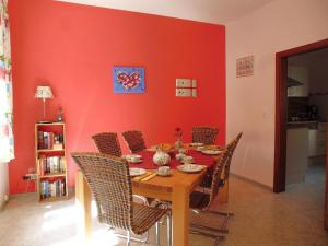 摩泽尔河畔的泽尔Ferienhaus Alte Mühle的一张带椅子的餐桌和红色的墙壁