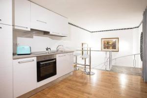 罗马Unforgettable Split Level Jacuzzi Suite Navona - Top Collection的白色的厨房设有水槽和炉灶。