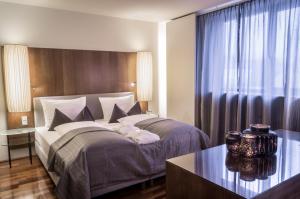 因斯布鲁克朋兹酒店的一间卧室配有一张大床和一张桌子