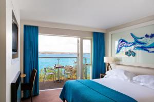 阿德莫尔崖屋酒店的一间卧室配有一张床,享有海景