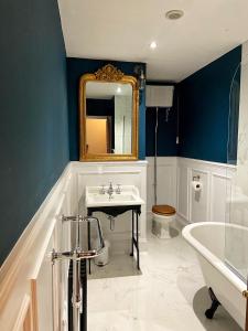 科宁斯比莱格特酒店的浴室配有盥洗盆、镜子和浴缸