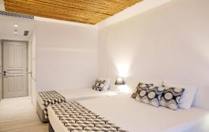 纳克索乔拉托马斯一室公寓酒店的一间卧室设有两张床和木制天花板