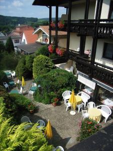 巴特柯尼希Hotel Schloessmann Garni的庭院配有白色的桌椅和黄色的遮阳伞。