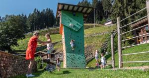 卡顿巴赫Alpin Family Resort Seetal的操场上攀爬墙上的妇女和儿童