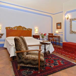 蒙特普齐亚诺伊尔荣多精品酒店的一间卧室配有一张床、一把椅子和一张桌子