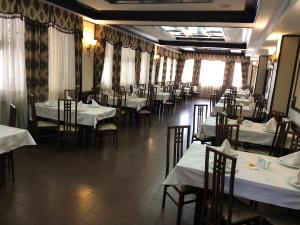 罗曼Hotel Onix的用餐室配有桌椅和白色的桌布