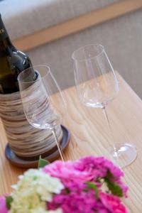 朗根旺克莱纳酒店-餐厅-咖啡厅的桌子上放有两杯酒杯和一瓶及鲜花