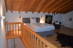 内卡苏尔姆普林茨城市公寓式酒店的一间卧室配有白色床单和木制天花板。