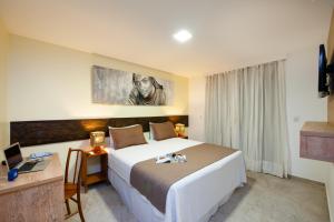 莫罗圣保罗普萨达巴伊亚巴坎纳旅馆的酒店客房设有一张大床和一张书桌。