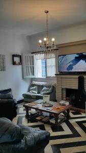 维拉卡洛斯帕兹Blau Hostel的客厅配有咖啡桌和电视