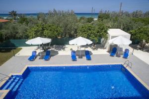 阿尔加卡Rafaella Beach Villa- Pvt Pool-Near Sea/Beach的一个带椅子和遮阳伞的游泳池