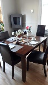魁北克市特朗斯特住宿加早餐酒店的客厅配有一张带黑色椅子的木桌