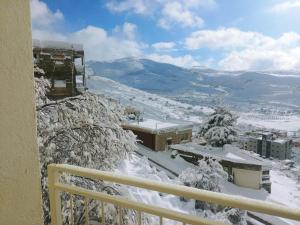 迈季代勒舍姆斯Jasmin Suites的从雪地建筑的阳台上可欣赏到风景