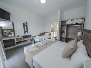 斯卡拉马里昂利亚一室公寓的一间带白色大床的卧室和一间浴室