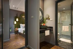 河内Hanoi Center Silk Hotel & Travel的带淋浴、床和镜子的浴室
