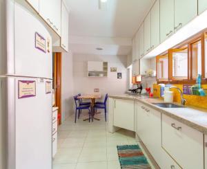 圣保罗MADÁ hostel的厨房配有白色橱柜和桌子