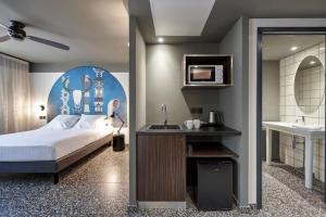 圣丹尼斯DINA MORGABINE SAINT DENIS的一间卧室配有床、水槽和镜子