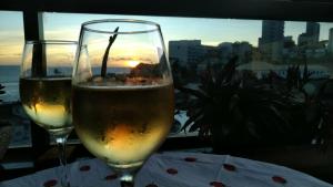 萨尔瓦多Beira Mar Rio Vermelho 02的两杯酒坐在桌子上,欣赏日落美景