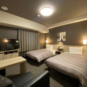 TokaiRoute Inn Grantia Tokai Spa&Relaxation的酒店客房设有两张床和电视。