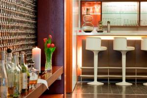 塞尔布Hotel & Restaurant Rosenthal Casino的酒吧设有白色凳子和瓶装葡萄酒