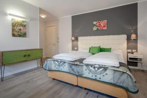 梅拉诺亚仕达酒店的一间卧室配有一张绿色的大床