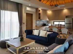 盼武里Pranatarn Pool Villa Beach Night Cottage的一间带蓝色沙发的客厅和一间厨房