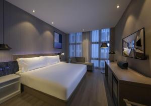 上海桔子酒店(上海浦东机场店)酒店提供浦东机场免费接送服务的卧室配有一张白色大床和电视。