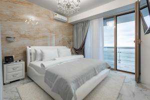 索契Wellness СПА-Отель Грейс Горизонт的卧室设有白色的床和大窗户