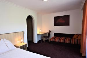 萨尔巴赫Hotel Sommerer - inklusive JOKER CARD im Sommer的配有一张床和一张书桌的酒店客房