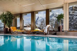 米伦Eiger Mürren Swiss Quality Hotel的一个带游泳池和山脉的度假胜地