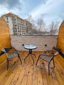 贝尔格莱德Super seven inn的木甲板上配有两把椅子和一张桌子