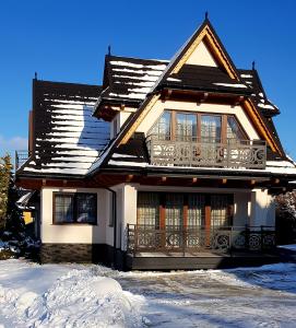 穆扎希赫尔Domki U Hani的雪盖屋顶的房子