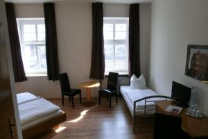 萨勒河畔哈雷Hotel Schweizer Hof的客厅配有床、椅子和窗户
