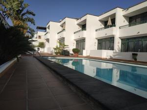 卡门港Apartamentos La Tegala的大楼前的游泳池