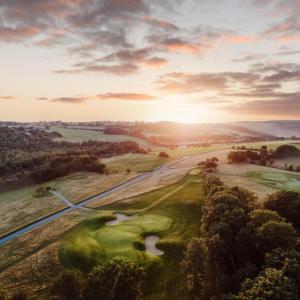 巴斯塔德Bjäre Golfklubb Hotel & Lodge的享有高尔夫球场的空中美景,享有日落美景