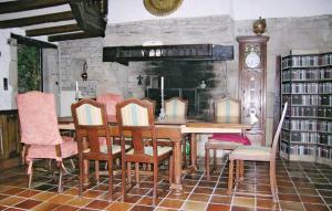 ScaërCrémoren Cottages的一间带桌椅和时钟的用餐室