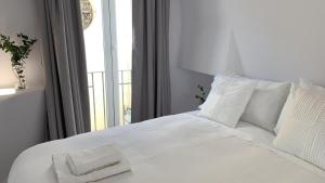 科尔多瓦Hotel Boutique Suite Generis, Premiado El hotel más acogedor de España的白色的床、白色枕头和窗户